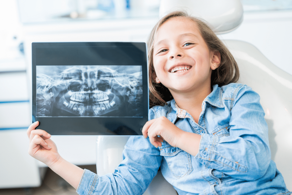 Child holding a dental X-ray during an orthodontic evaluation for crowded teeth in Houston TX